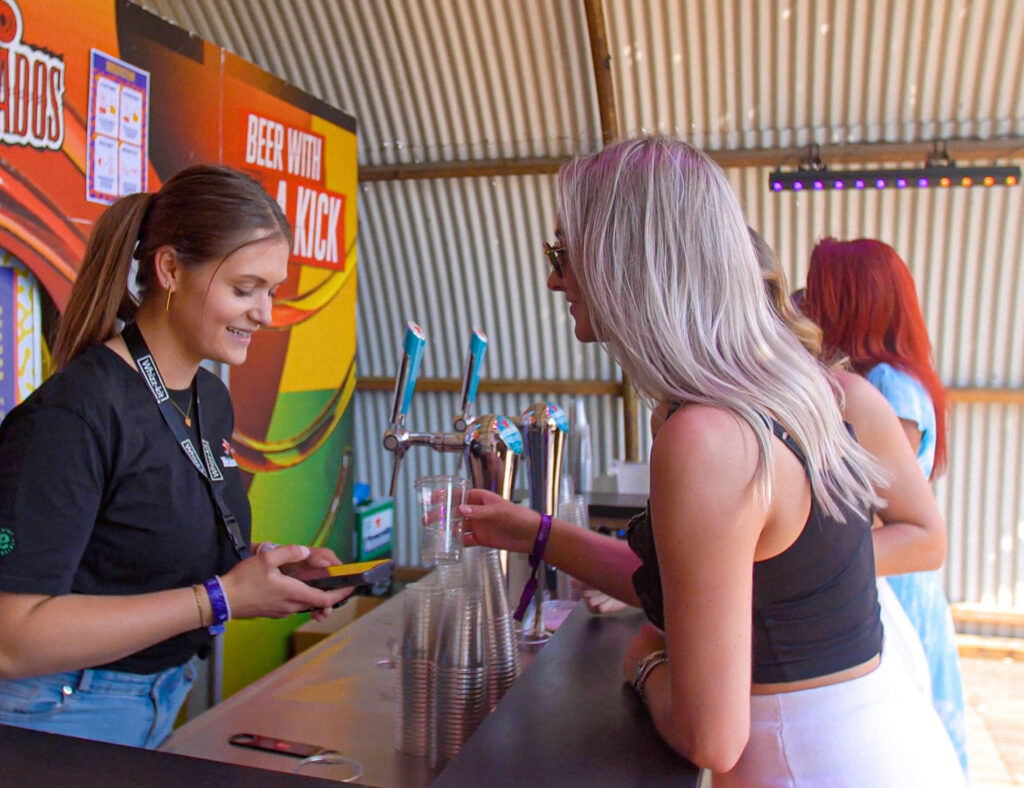 Festivalganger rekent cashless af aan de bar bij een horeca kassasysteem.